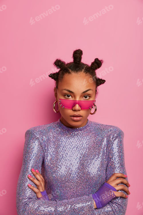 Preview: Indoor shot of serious Afro American female model stands with arms folded, looks calmly at camera, w