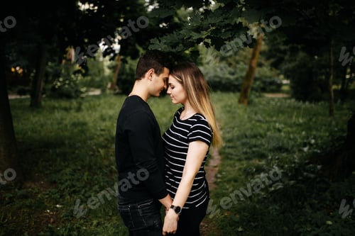 Preview: Young happy couple walking in park