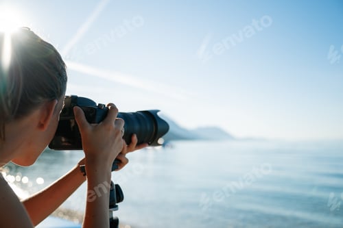 Preview: Professional female photographer taking photo of beautiful morning sea