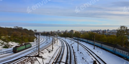Preview: Winter landscape with a railway train on a railway surrounded by a city panorama with lots of houses