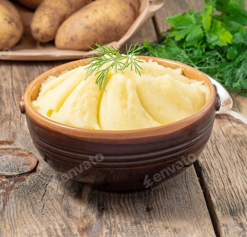 Preview: Mashed potatoes, boiled puree in brown bowl on dark wooden rustic background, side view
