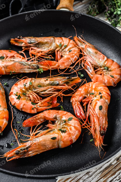 Preview: Grilled tiger shrimps Prawns with spice and lemon in a pan. White wooden background. Top view