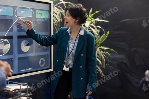 Preview: Woman consultant examining monthly sales infographics on interactive board