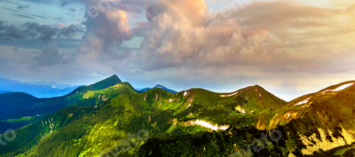 Preview: Wide panorama of lit by morning sun green valley, hills covered with forest