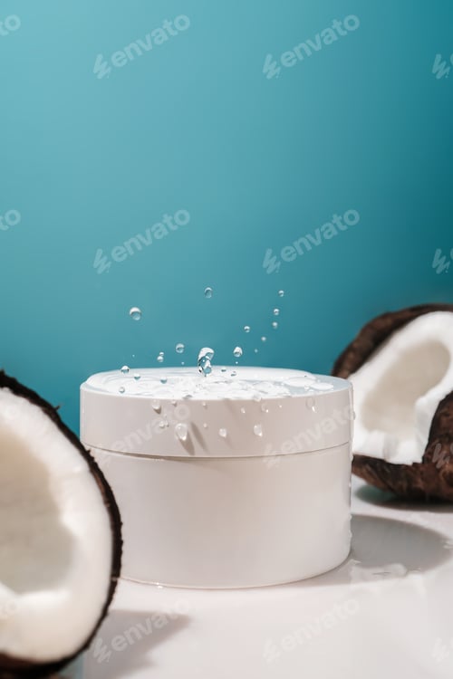 Preview: Two halves of coconut and a jar of cosmetics on a blue background with water drops.