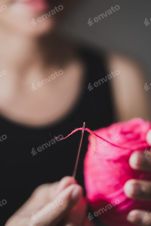Preview: Woman fingers threading a needle
