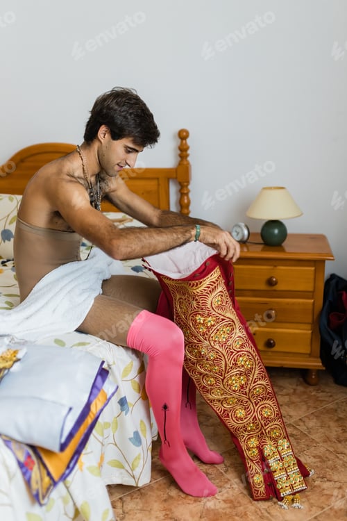 Preview: Hispanic bullfighter putting on pants on bed