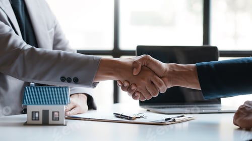 Preview: Real estate agent shakes hands with a client to sign a home purchase contract congratulating