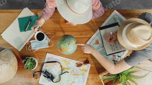 Preview: Top view of young couple with maps planning vacation trip holiday, desktop travel concept