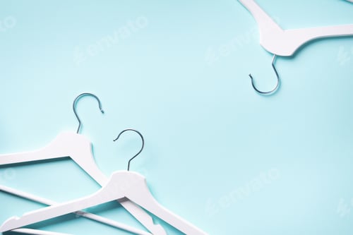 Preview: Top view of white clothes hangers on blue background with copy space. Flat lay. Minimalism style