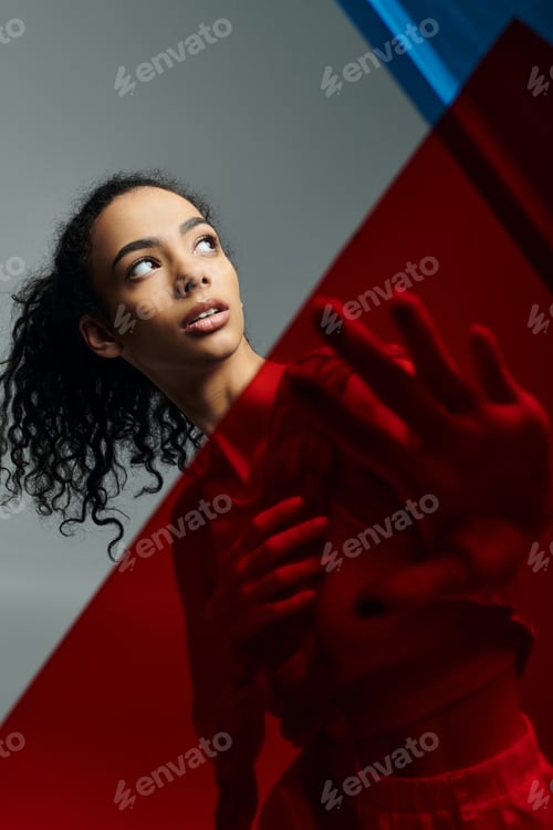 Preview: African american athlete posing in red studio light