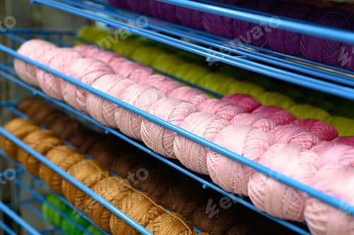 Preview: rows of balls of colorful cotton yarn threads for knitting pale pink and mustard colors