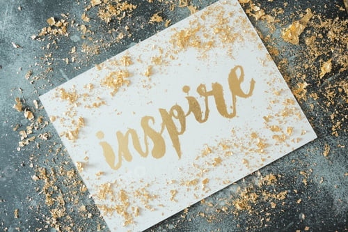 Preview: Inspire. Motivating lettering on white board. Handmade creativity. Gold letters. Gilding.