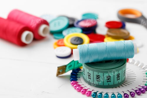 Preview: Colorful sewing accessories on white wooden table