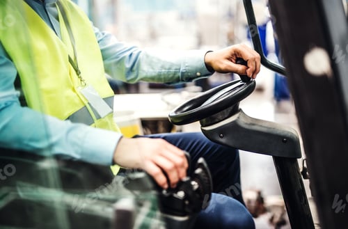 Vista previa: Unrecognizable industrial man engineer sitting in a forklift in a factory.