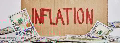 Preview: World inflation concept. Cardboard with word inflation and usd banknotes
