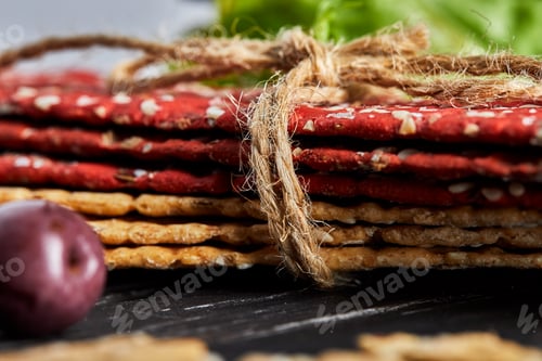 Preview: Beetroot and rye flour crackers with vegetables for making snacks on a black background.