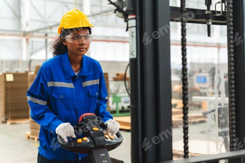 Preview: African American female worker driving forklift truck in heavy metal industrial factory
