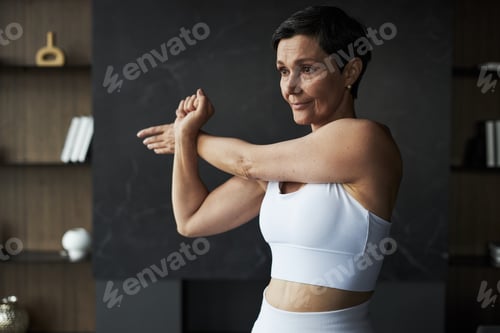Preview: Caucasian Middle Aged Woman Warming up Arms before Indoor Fitness Training