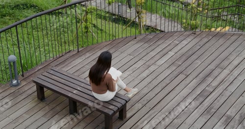 Preview: Woman read a book and sit on the bench at park
