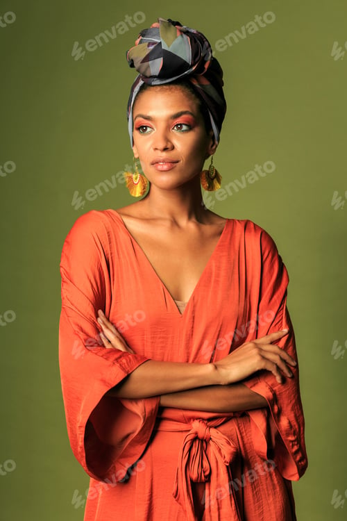 Preview: Young black african woman wearing orange dress with turban and ethnic jewelry