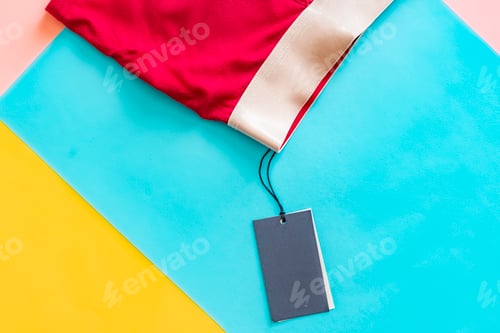 Preview: flat lay of new male red underwear pants isolated with blank price tag on creative color background