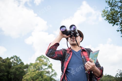 Preview: Young with Binocular onwith outdoor forest on background Travel concept.