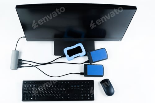 Preview: Multiple external hard drives connected to a monoblock on a white background.Computer with hard