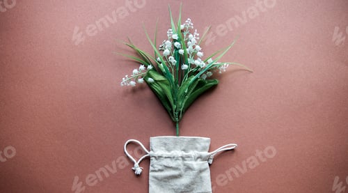 Preview: Flower decor bouquet lily of the valley isolated on brown background, top view,copy space,plastic