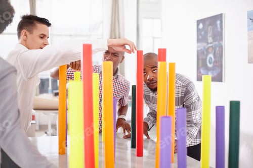 Preview: Colleagues in team building task balancing colourful tubes