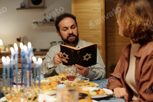 Preview: Serious mature Jewish man with open Torah reading Scripture texts