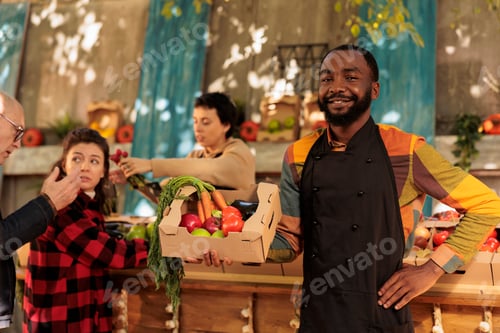 Preview: Cheerful small business owner posing at farmers market