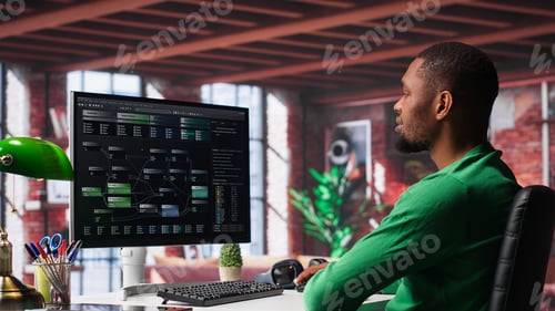 Preview: African american man looking at UI on PC screen at home office