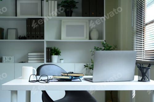 Preview: Modern home office setup with laptop, notebooks, and coffee mug on a white desk