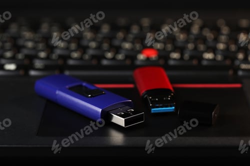 Preview: Modern usb flash drives on laptop, closeup