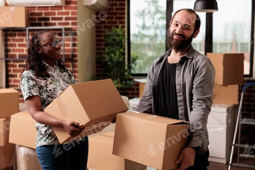 Preview: Portrait of diverse life partners posing with boxes on moving day