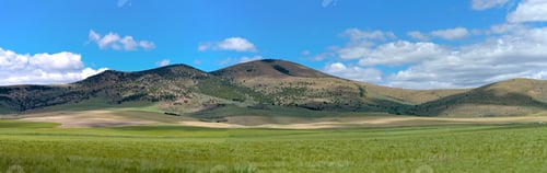 Preview: Panoramic shot of beautiful green mountains with an agricultural field