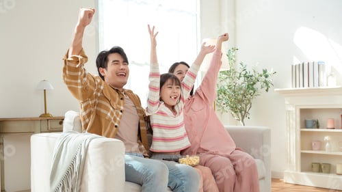 Preview: Family Watching TV Together at Home With Excitement and Surprise During the Evening Time