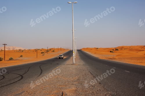 Preview: Winding black asphalt road through sand dunes