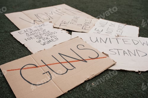 Preview: Say no to guns. Group of banners with different feminist quotes lying on the ground