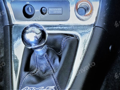 Preview: Car Bling! A chrome shifter and black leather boot in a sports car with black interior.