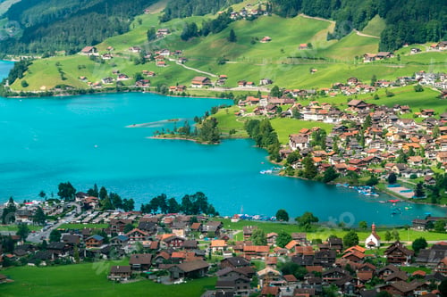 Preview: Scenic view of a vibrant lakeside village surrounded by lush greenery