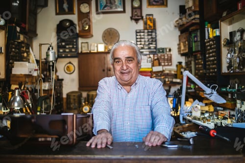 Preview: Senior watchmaker smiling in his authentic workshop