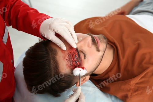 Preview: Nurse cleaning young man's head injury in clinic. First aid