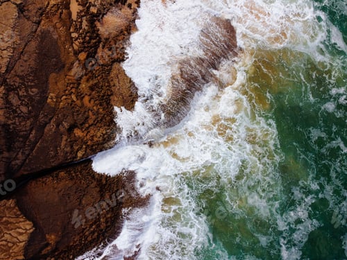 Preview: Aerial top view of sea waves hitting rocks on the cliffs