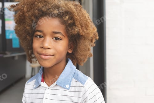 Preview: Front view of African ethnicity schoolboy smiling while looking at camera