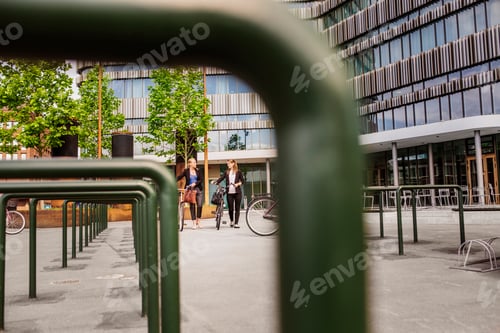 Preview: Two women with bicycles walking in city