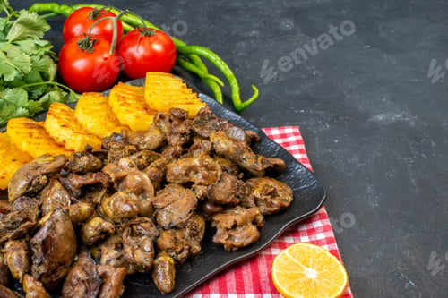 Preview: bottom view chicken liver fry with potato on platter tomatoes hot green peppers coriander on table
