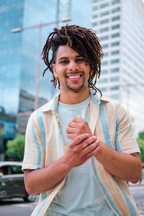 Preview: portrait of a young latin man surrounded with modern city buildings