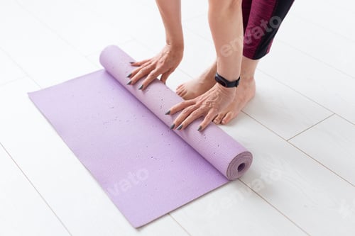 Preview: Woman Rolling Up Yoga Mat After Workout